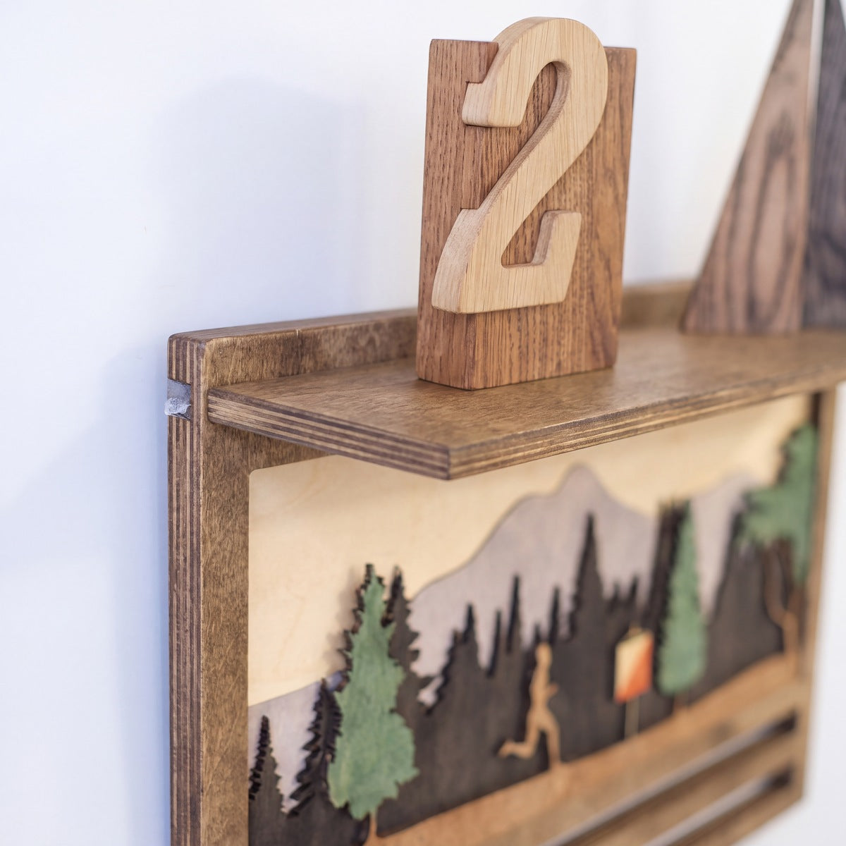 Medal Display with Trophy Shelf — close-up of the engraved wooden detail | Story of Miles